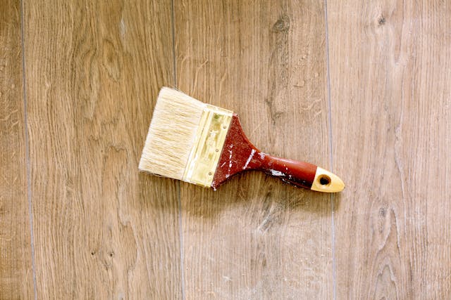 a paintbrush on wooden flooring